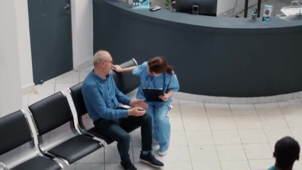 Různorodá Skupina Pacientů Kteří Čekají Lékařskou Prohlídku Sedí Rušné Recepci — Stock video