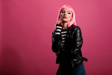 Portrait of attractive beautiful lady posing in front of camera, wearing trendy leather jacket to feel stylish and carefree. Female punk rocker with pretty fashion style having fun.