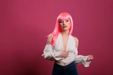 Portrait of caucasian beautiful girl with cool makeup look and pink hair, looking at camera and feeling carefree. Female model with trendy fashion style looking elegant and atrractive in studio.
