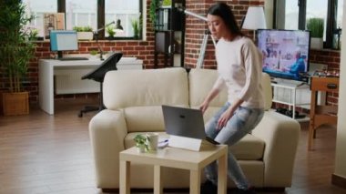 Beautiful freelancer doing remote work on modern laptop while developing business ideas at home. Hurried young adult woman working remotely on startup project because of early deadline.
