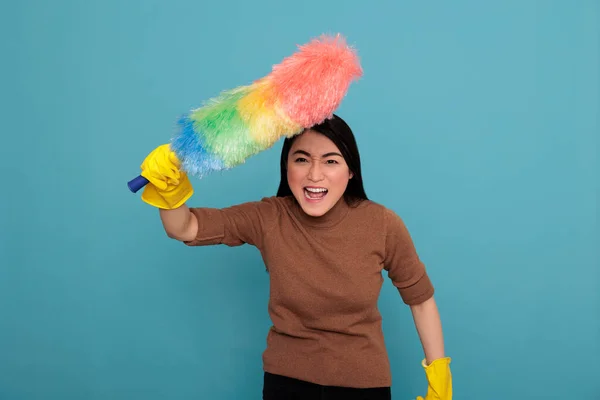 Angry Energetic Young Asian Houseworker Holding Colorful Dust Brush Yellow — Stockfoto
