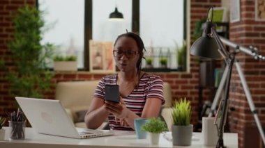 Young adult attending online business conference meeting on smartphone, working remotely on videocall with webcam. Talking to colleagues on remote teleconference internet connection.