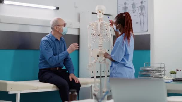 Medical Assistant Showing Human Skeleton Bones Old Patient Consultation Covid — Stock video