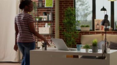 Freelancer woman sitting at home desk and working remotely on startup network, using laptop with online connection. Doing remote work and freelance job on computer at home, virtual webinar.