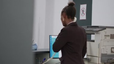 Medical assistant and asian doctor talking about appointments with checkup report papers, working at hospital reception desk. Diverse team of specialists helping with insurance support.