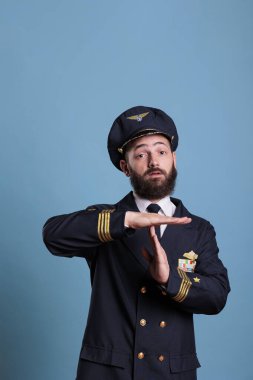 Uçak pilotu el hareketleriyle mola veriyor, kameraya dur sinyaliyle bakıyor. Havacılık akademisi kaptanı önden görüş, hava kuvvetleri pilotu mola tabelası, mola, müdahale