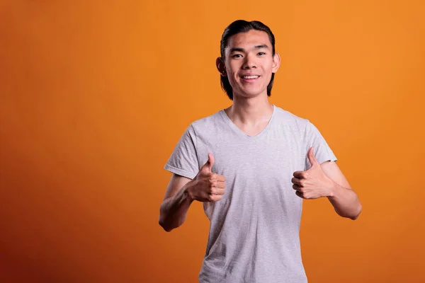 Genç Gülümseyen Asyalı Adam Baş Parmakları Havada Bir Portre Çiziyor — Stok fotoğraf