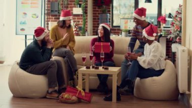 İş arkadaşlarım Noel arifesini hediyelerle kutluyorlar Noel partisinde Noel Baba şapkası takıyorlar. İnsanlar süslemelerle süslenmiş hediyelerini ofiste değiş tokuş ediyorlar. Üçayak atışı.