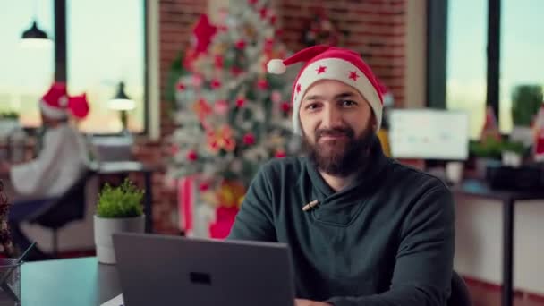 책상에서 노트북을 사용하는 사무직 노동자의 초상화 직장에서 모자를 크리스마스를 축하하기 — 비디오