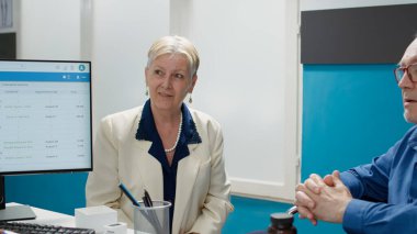 Afrikalı Amerikalı doktor fiziksel engelli bir adamla konuşuyor. Engelli bir hastaya danışıyor. Doktor, sağlık dolabındaki sağlık kontrolünde tekerlekli sandalye kullanıcısını muayene ediyor..