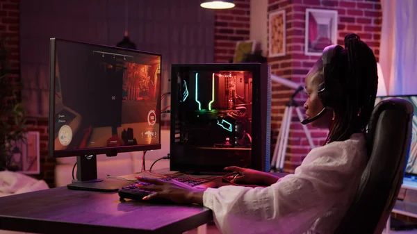 Gamer transmitindo o jogo de tiro em primeira pessoa enquanto explica a  jogabilidade aos assinantes enquanto está sentado na cadeira de jogos.  homem usando a configuração do pc jogando jogo de ação