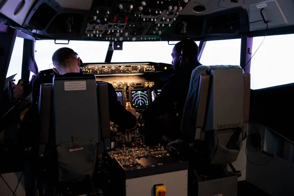 Multiethnic team of pilots using control command to fly plane in ...
