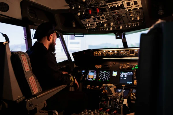 Caucasian plane captain getting ready to takeoff and fly airplane using control command and power buttons on dashboard in cockpit. Piloting aircraft with panel navigation switch.