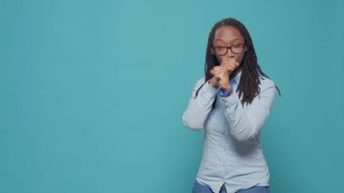 Portrait of female boxer punching air with clenched fists, boxing in defense. Being offensive and aggressive to kick and do sparring in physical force confrontation, hitting and banging.