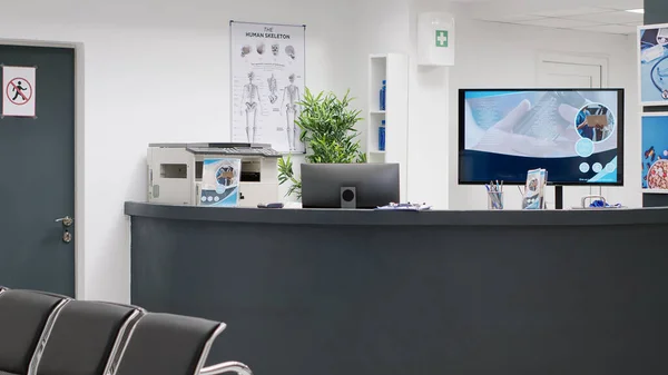 Healthcare facility reception counter in hospital, space used for medical appointments or checkup visits with specialists. Empty waiting area and hallway lobby, private examination clinic.