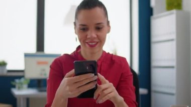 Proje araştırması için interneti taramak için akıllı telefon kullanan pazarlama deneyimi olan satış asistanı. İş kadını işe ara veriyor ve internet sitesindeki uygulamalara göz atıyor.