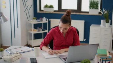 Kadın danışman not almak için rapor kağıdı kullanıyor, finansal büyüme için iş stratejisi yaratıyor. Ofis çalışanı istatistik ve satış şemalarıyla geliştirme planlıyor.