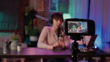 Seçici odak noktası dijital video kamera kaydı beyaz video blogcusu ev podcast stüdyosundan izleyicilerle konuşuyor. Sosyal medya için canlı yayın yaparken kendini filme çeken kadın etkili..
