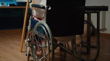 Tekerlekli sandalye kullanıcısı, fiziksel engellilikten muzdarip, hobi için profesyonel başyapıt çiziyor. Sanatsal becerileri ve yetersizliği olan felçli bir kadın sanat eskizi çiziyor..