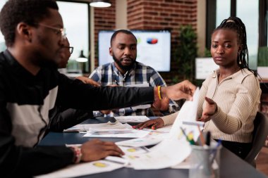 İş arkadaşları iş toplantılarında fikir üretmek, belgeler hakkında bilgi içeren bir başlangıç sunumu yaratmak için birlikte çalışmak. Planlama şirketi dizüstü bilgisayar ve evrak işlerini rapor ediyor..