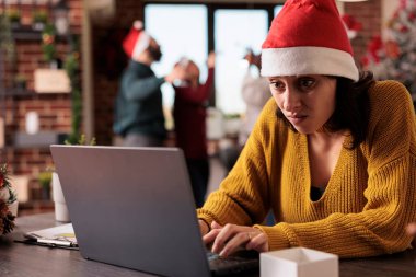 Gürültülü ofiste çalışan sinirli bir kadın, iş yerindeki meslektaşları tarafından rahatsız edilmiş, bayram süsleriyle süslenmiş. Kurumsal alanda çalışmaktan yorgun düşmüş biri..