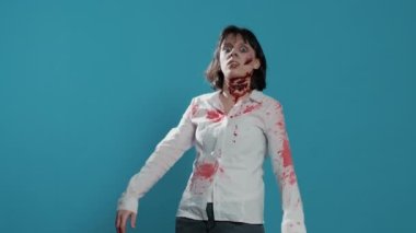 Ürkütücü zombi kadın mavi arka planda homurdanırken tuhaf ve uğursuz davranıyor. Derin ve kanlı yaraları ve kameraya bakan yaraları olan beyinsiz, beyin yiyen kötü canavar. Stüdyo çekimi
