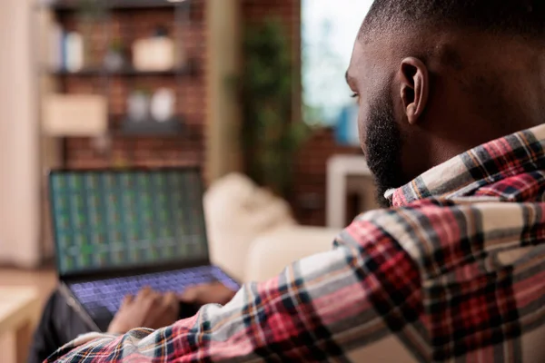 Office worker looking at stock market statistics, analyzing real time index profit exchange to do global money investment. Working remotely with capital trade business on laptop computer.