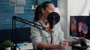 Profesyonel podcaster video kaydına başlarken kulaklık takıyor. Yaratıcı dijital içerik oluşturucu halka hayat hikayeleri anlatırken kanal için çekim yapıyor.