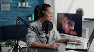 Radio talk show host answering audience questions on laptop while recording video. Creative content creator chatting with public on live chat while speaking on modern microphone.