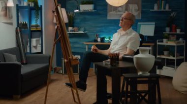 Emekli insan, sanat ve zanaat şaheseri yaratmak için sanat aletleri ve ekipmanları kullanarak tuval kağıdına kalemlerle vazo tasarımı yapıyor. Modern sanat modelini yaratıcılıkla çizmek.