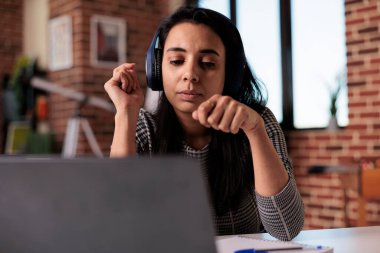 Bilgisayarda kulaklıkla çalışan, müzik dinleyen ya da uzaktan yayın yapan genç bir serbest yazar. Webinar dersine katılmak ya da ofiste bilgisayar kullanırken şarkıdan keyif almak.