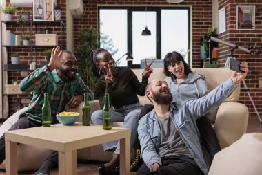 Ev partisinde akıllı telefonla fotoğraf çeken mutlu bir arkadaş grubu arkadaşlığı içkilerle kutluyorlar. İnsanlar eğlenceli fotoğraflar, selfie 'ler, boş zaman aktiviteleriyle anılar yaratıyor..