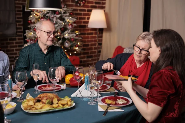 Familia Celebrando Navidad Teniendo Una Cena Festiva Pasando Plato Con — Foto de Stock