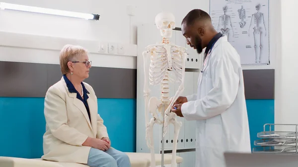 Male Osteopath Examining Human Skeleton Bones Senior Woman Analyzing Anatomy — Stockfoto
