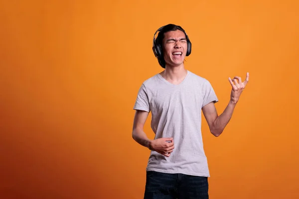 Jonge Aziaat Draadloos Hoofdtelefoon Speelt Virtuele Gitaar Rockster Levensstijl Tiener — Stockfoto