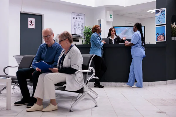 Paciente Enfermera Sentados Mostrador Recepción Hablando Con Recepcionista Sobre Diagnóstico —  Fotos de Stock
