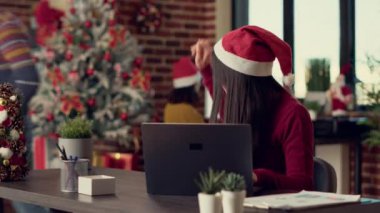 Kış tatilinde, başlangıç işinde fikir üreten, bilgisayar üzerinde takım çalışması yapan ve Noel Baba şapkası takan çeşitli kadınlar. Yılbaşı kutlamalarından önce ofiste çalışmak.