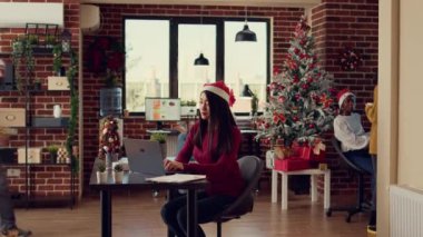 Çeşitli insanlar iş arkadaşlarına hediyeler ve hediyeler veriyor, kış tatilini şirket ofisindeki şenlikli süslemelerle kutluyorlar. Noel Baba şapkalı iş arkadaşları Noel sezonunda neşeli hissediyorlar..