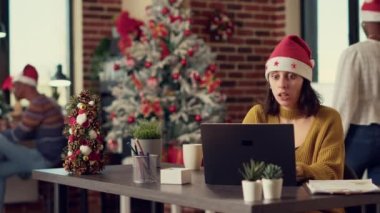 Ofis çalışanları Noel arifesini hediyelerle kutluyor, iş arkadaşlarıyla hediye alışverişinde bulunuyorlar. Uzayda neşeli ve neşeli hissediyorum. Noel ağacı ve mevsimlik dekorasyonlarla. Üçayak atışı.
