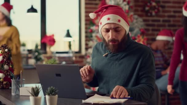 Mężczyzna Pracownik Kapeluszu Świętego Mikołaja Uroczystym Biurze Pracuje Nad Laptopem — Wideo stockowe