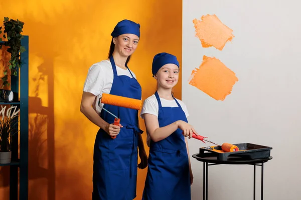 아파트 주황색 페인트를칠 단장을 가족의 도구와 페인트붓을 사용하여 내부에 그림을 — 스톡 사진