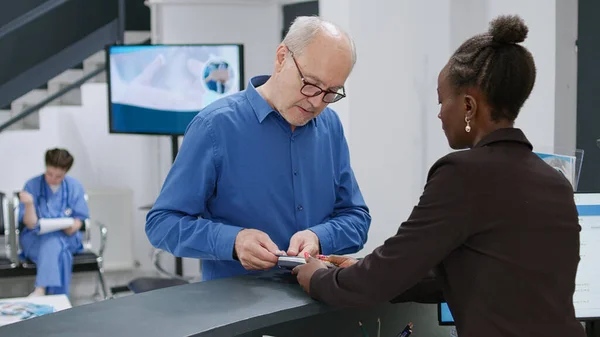 Senior Man Paying Credit Card Hospital Reception Desk Making Electronic — Stock Photo, Image