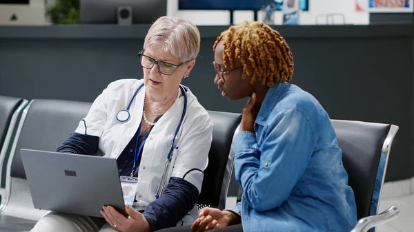 Starszy Lekarz Pokazujący Diagnozę Choroby Młodej Kobiecie Laptopie Wyjaśniający Leczenie — Zdjęcie stockowe