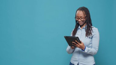 Modern yetişkin internet sitesi dijital tablet üzerinde sosyal medya uygulaması ve çevrimiçi ağ üzerinden kaydırmak için aygıt kullanıyor. Dokunmatik ekranlı kablosuz aygıta bakmak ve pozitif hissetmek.