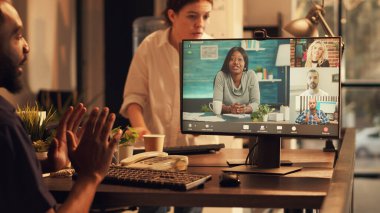 Erkek çalışan, internet kamerasıyla iş arkadaşlarıyla sohbet ediyor, gün batımında iş telekonferansına katılıyor. İşteyken internet bağlantısı için uzak video konferans çağrısı kullanılıyor.