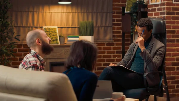 Terapi seansında erkek terapist, kadın ve erkeğe danışmanlık yapıyor, profesyonel rehberlik yapıyor. Terapi seansında evli bir çiftle psikoterapi görüşmeleri yapmak, sorunları çözmek..