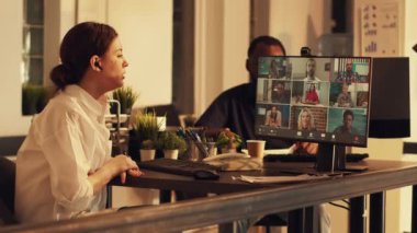 İş arkadaşlarıyla çevrimiçi telekonferansta konuşan, web kamerasıyla uzaktan kumandalı şirket toplantısına katılan bir şirket çalışanı. Kurumsal ofiste video konferans kullanılıyor..