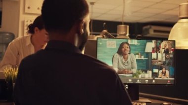 Bilgisayarda online video görüşmesine katılan bir ofis çalışanı web kamerası telekonferansında insanlarla konuşuyor. Gün batımında uzaktan konuşmak için video konferans çağrısını kullanmak. El kamerasıyla..