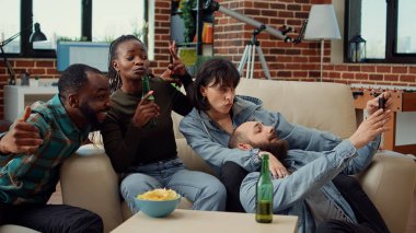 Çok ırklı bir arkadaş grubu akıllı telefondan komik fotoğraflar çekiyor, birlikte anılar yaratıyor ve ev partisinde gülüyorlar. Bira içmek ve fotoğraf çekmek için telefon kullanmak, aylaklık etmek..