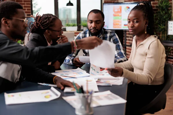 Proje planlamak için takım çalışması yapan iş adamları, belgelerle ilgili bilgi ve verileri analiz ediyorlar. Araştırma yapmak ve ofiste kurumsal sunum yaratmak için dizüstü bilgisayar ve evrak dosyaları kullanmak.